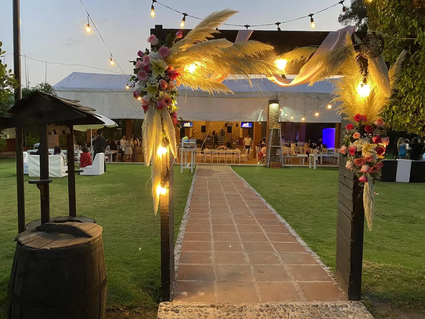 Entrada decorada con luces y flores al atardecer en Hacienda San Marcos